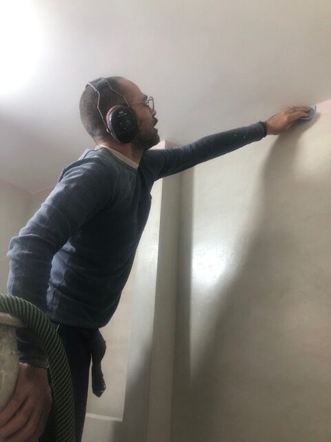 Jérémy Fargier, artisan peintre décorateur Full Déco, en train de poncer un enduit à Montpellier